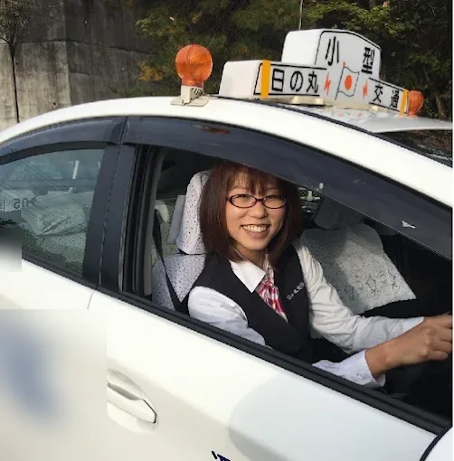日の丸交通の行燈を掲げたタクシーと乗務員